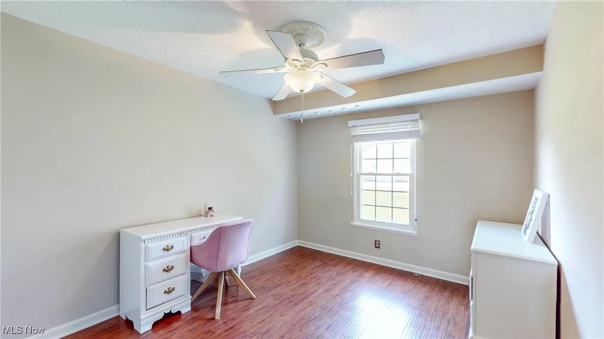 Office space featuring ceiling fan, wood finished floors, and a textured ceiling