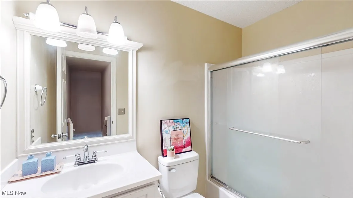 Bathroom with vanity and shower / bath combination with glass door