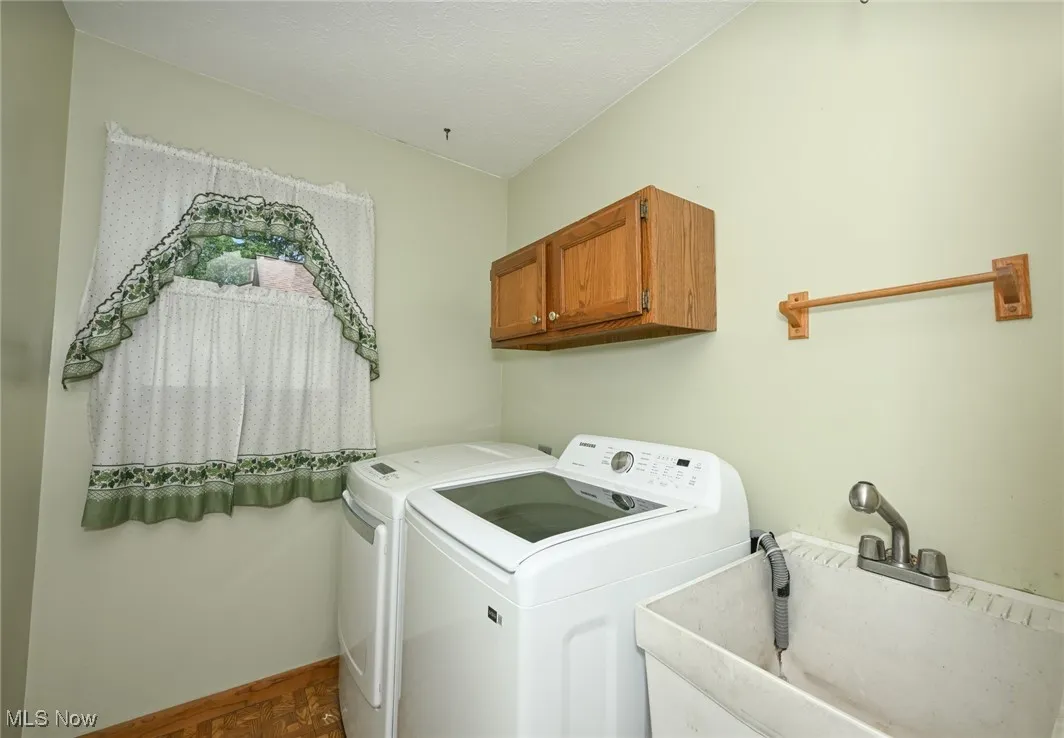 First floor laundry room with washing machine and dryer and cabinet space