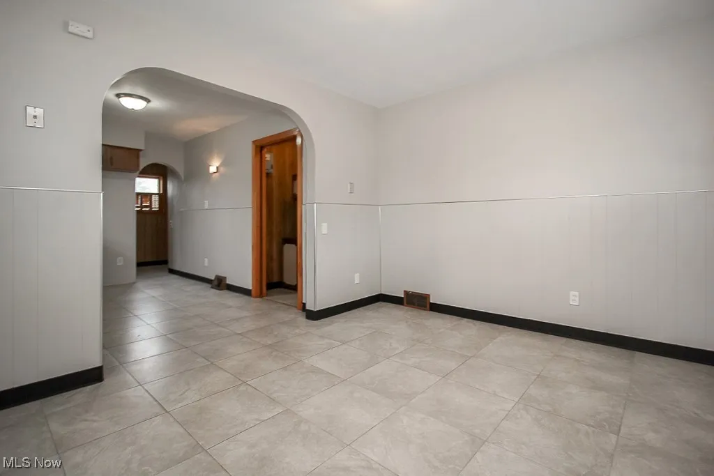 Spare room with arched walkways and light tile patterned flooring