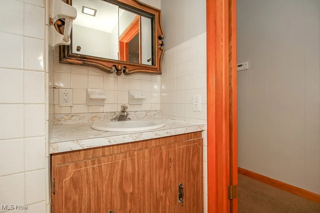 Bathroom featuring vanity and backsplash
