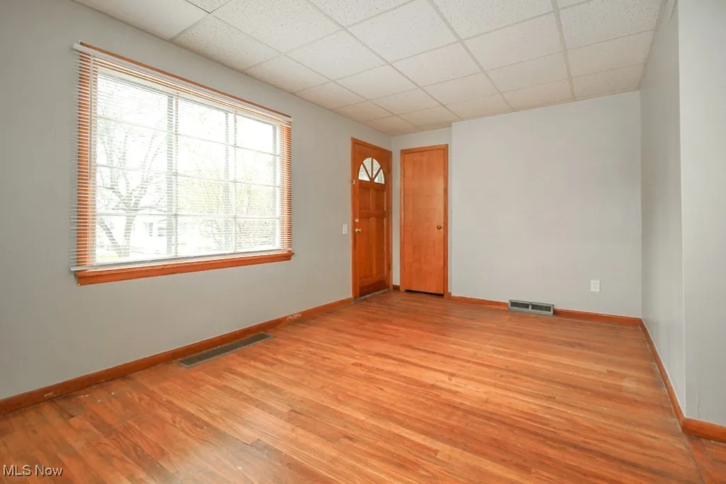 Spare room featuring a drop ceiling and light wood-style flooring
