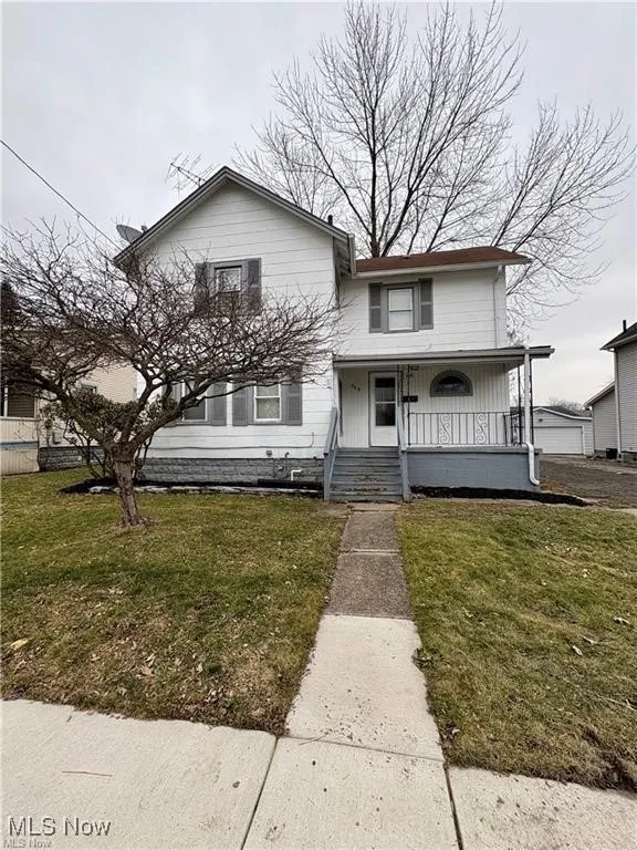 View of front of property featuring covered porch and a front lawn