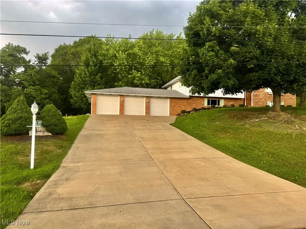 View of front of property featuring a front lawn, a garage, and brick siding