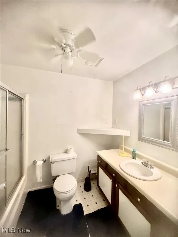 Full bathroom featuring vanity, ceiling fan, enclosed tub / shower combo, and tile patterned floors