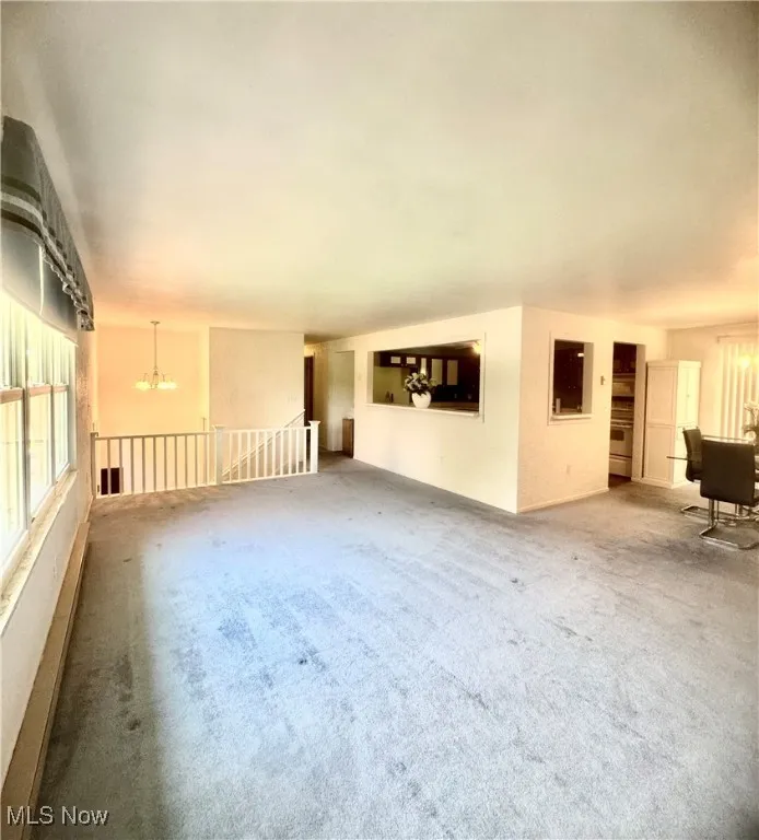 Carpeted empty room with a chandelier