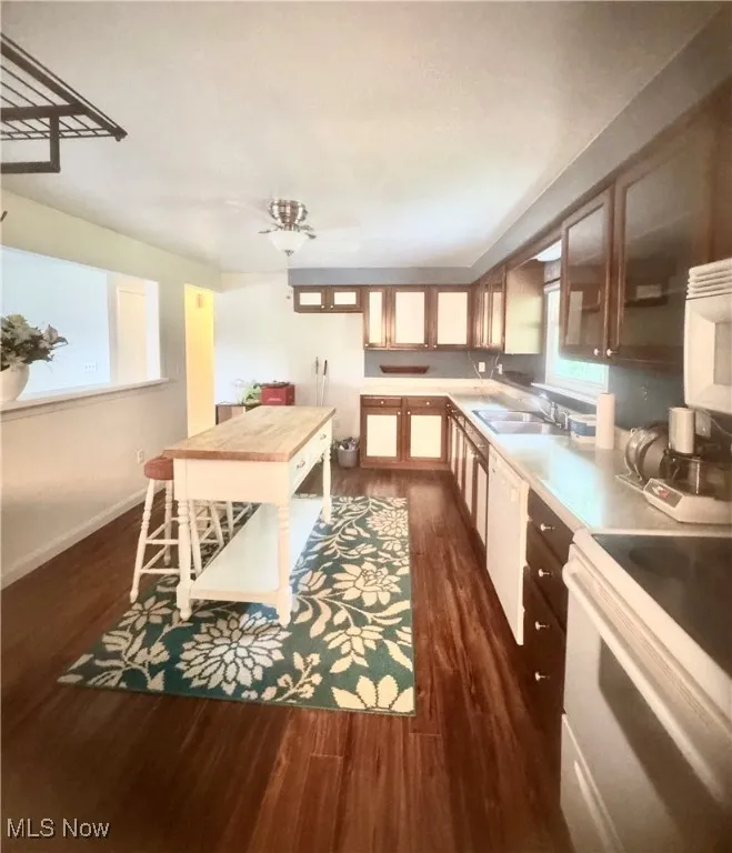 Kitchen with white appliances, dark wood-style floors, light countertops, and ceiling fan