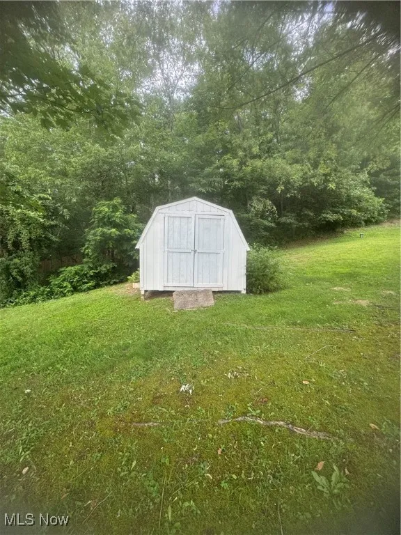 View of shed with a wooded view