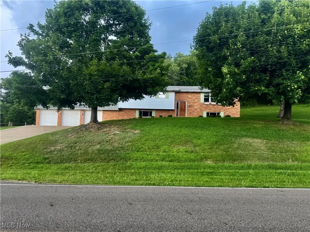 View of front facade with driveway and a front yard