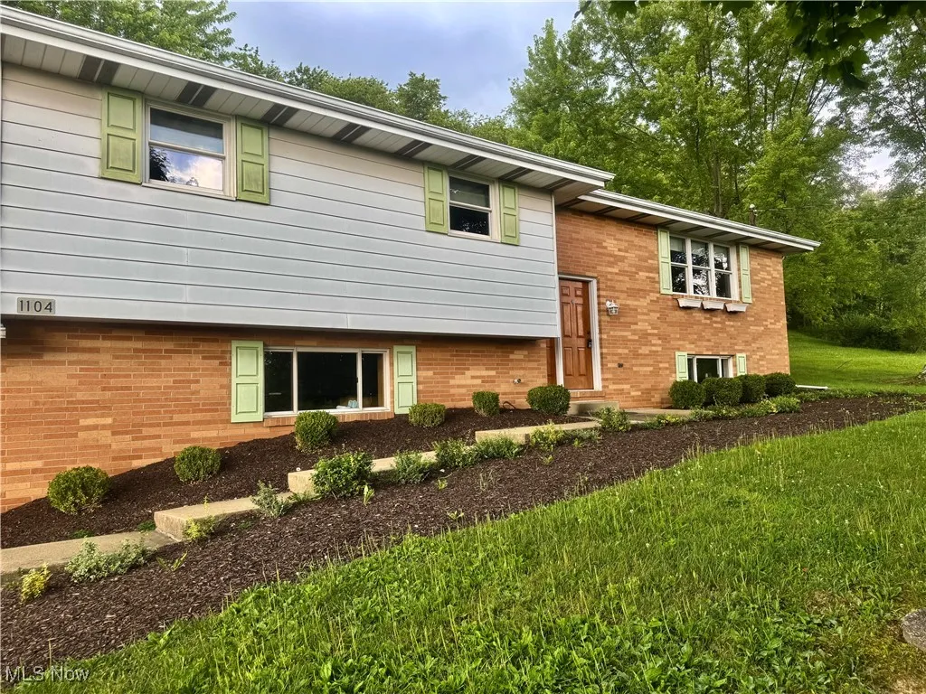 View of front of property with a front yard and brick siding