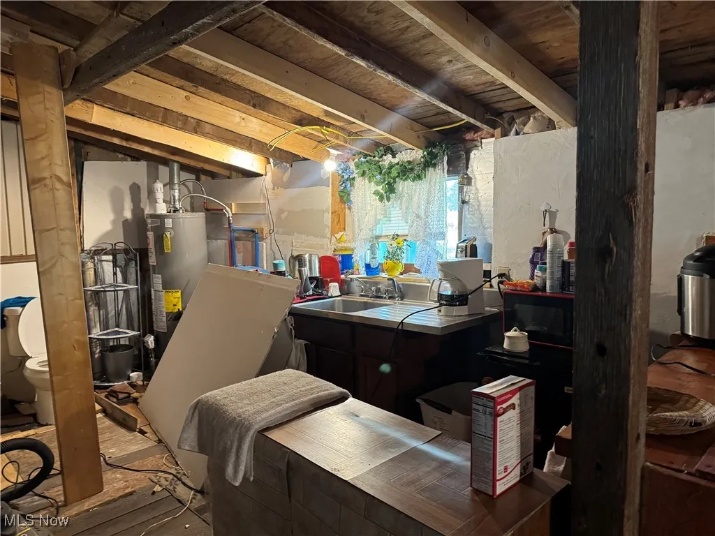 Below grade area featuring a sink and water heater