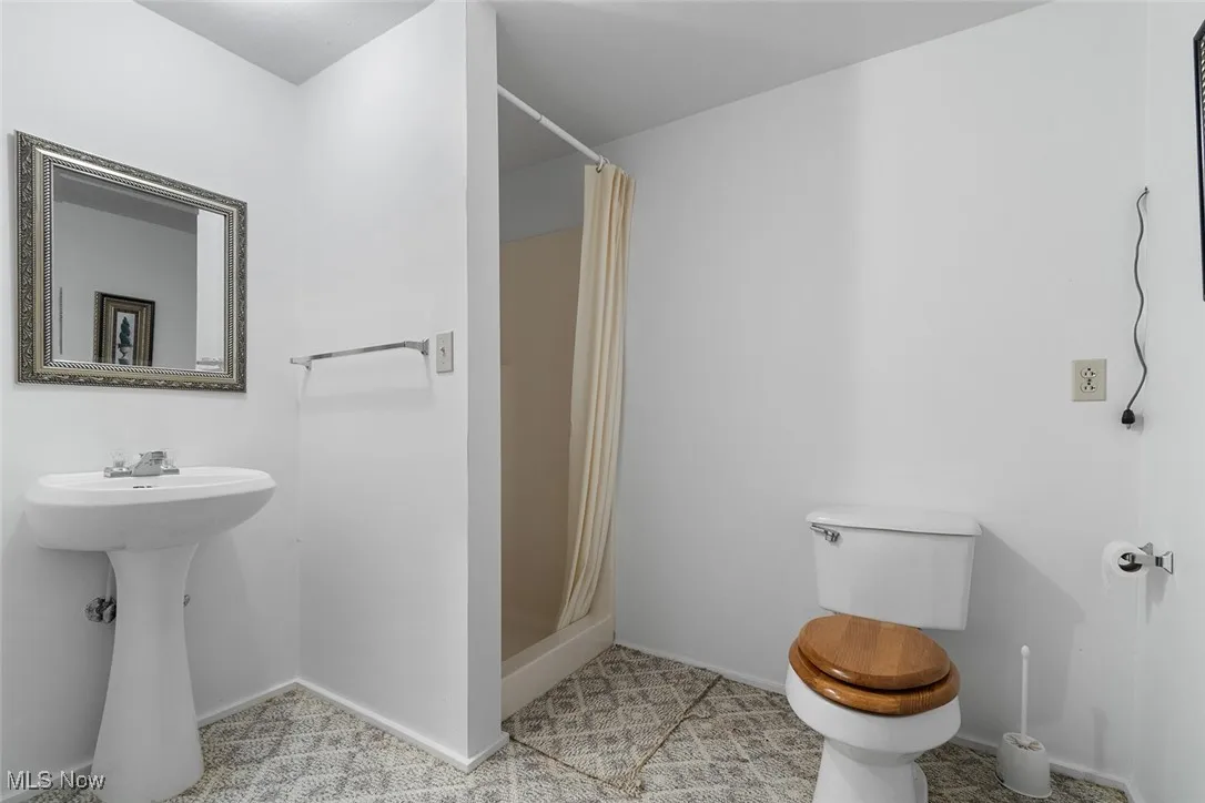 Full bathroom with toilet and a stall shower