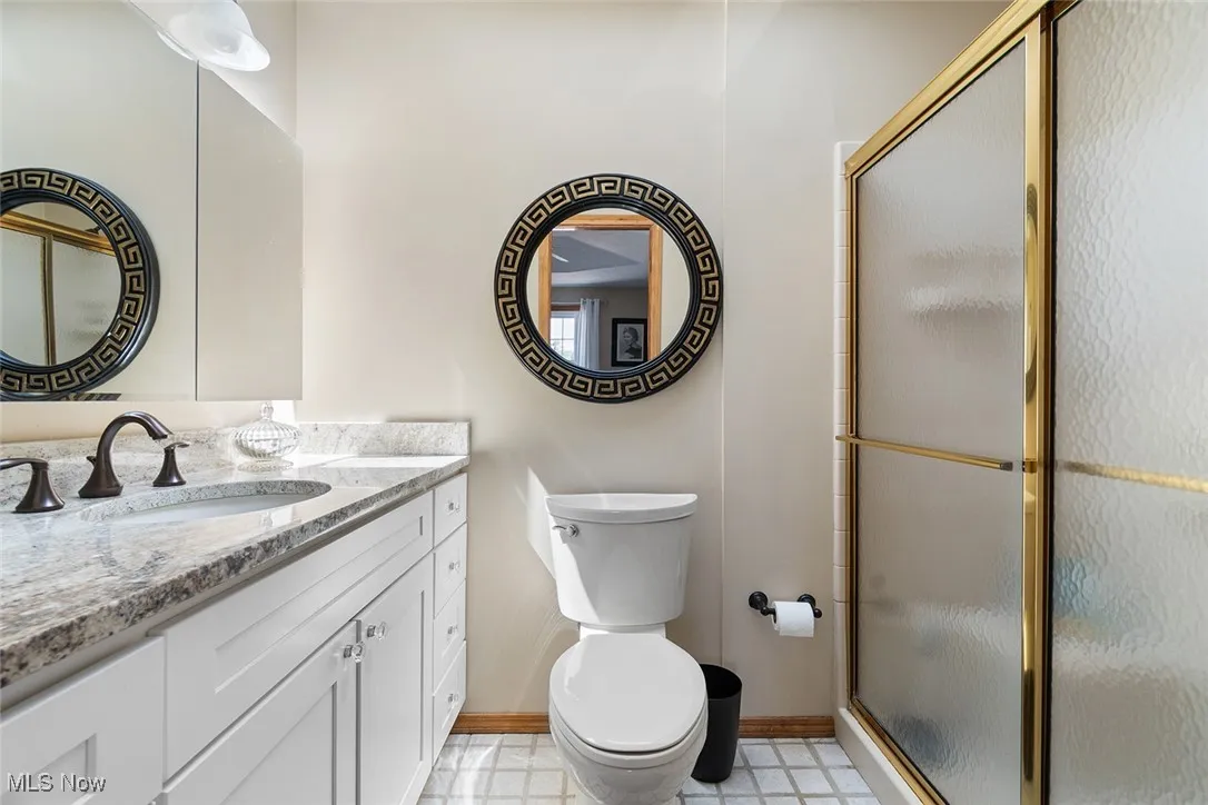 Full bath featuring a stall shower, vanity, and tile patterned floors