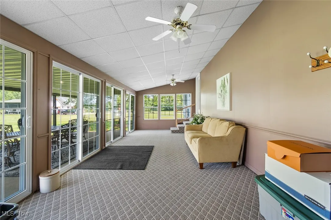 Sunroom / solarium featuring carpet flooring and lofted ceiling