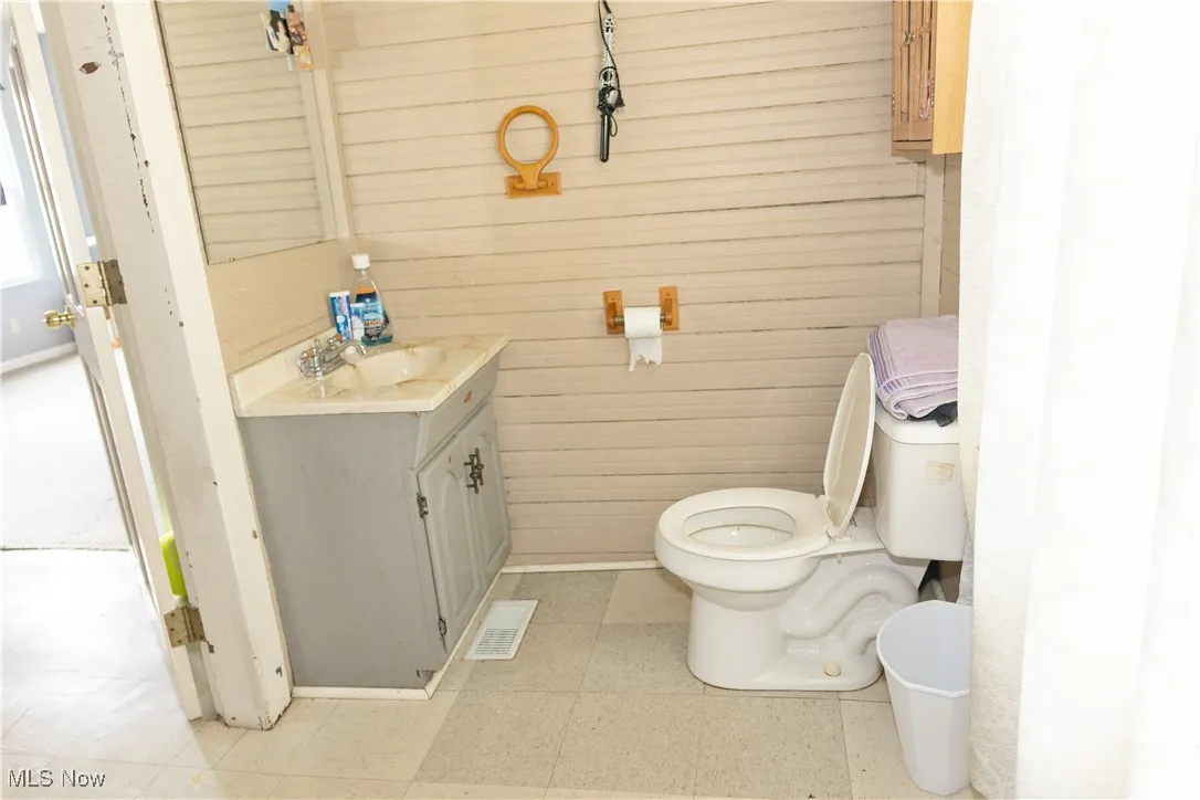 Bathroom with vanity and wood walls