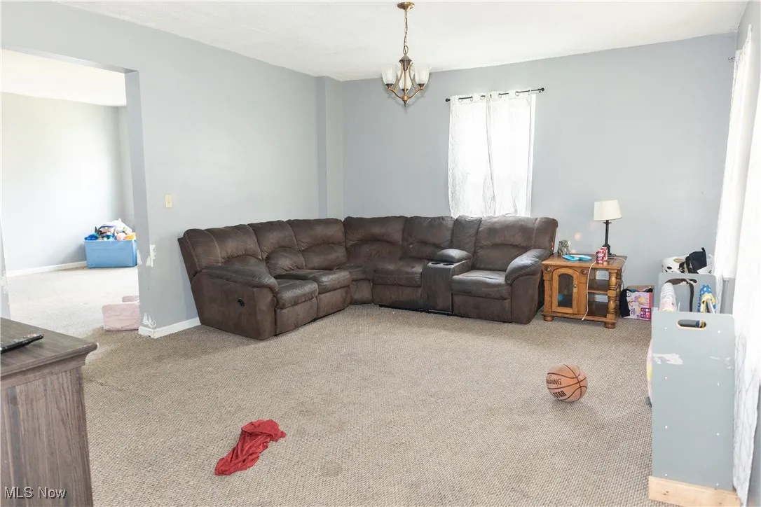 Living room with carpet floors and a chandelier