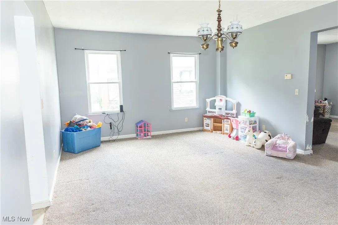 Recreation room with carpet flooring and a chandelier
