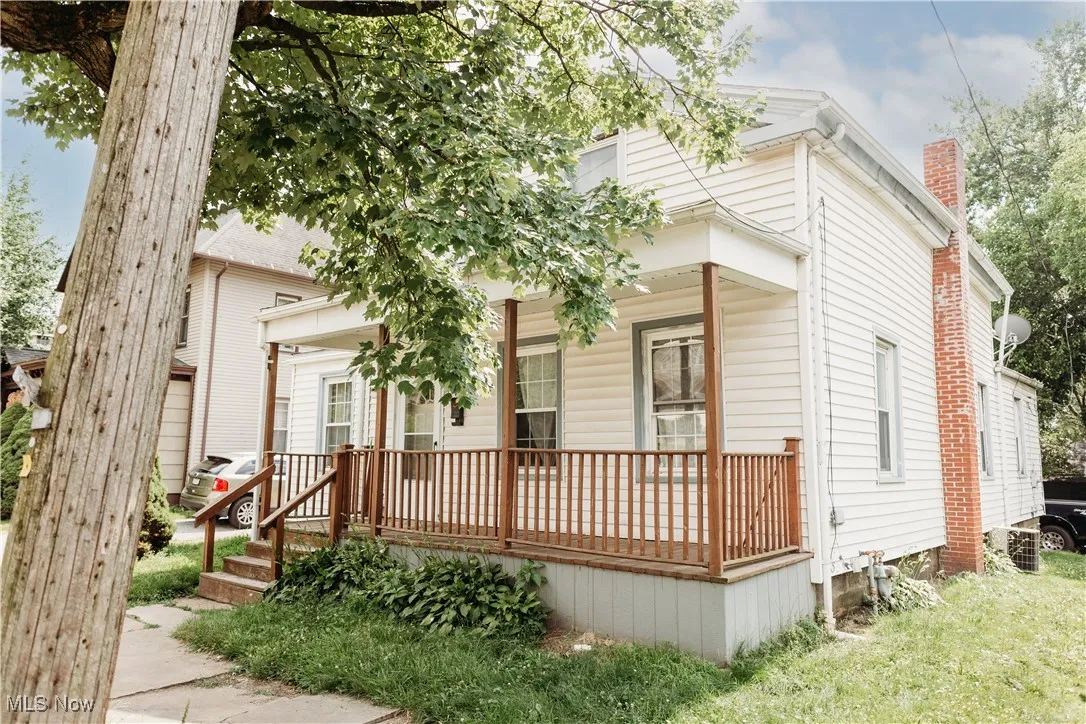 View of front of home with a porch and a chimney