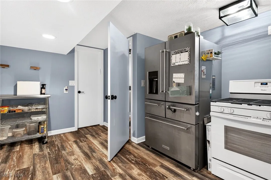 Kitchen featuring gas range gas stove, stainless steel fridge with ice dispenser, wood finished floors, and recessed lighting