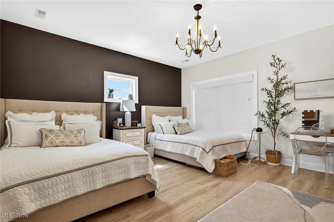 Bedroom featuring a chandelier and light wood-style floors