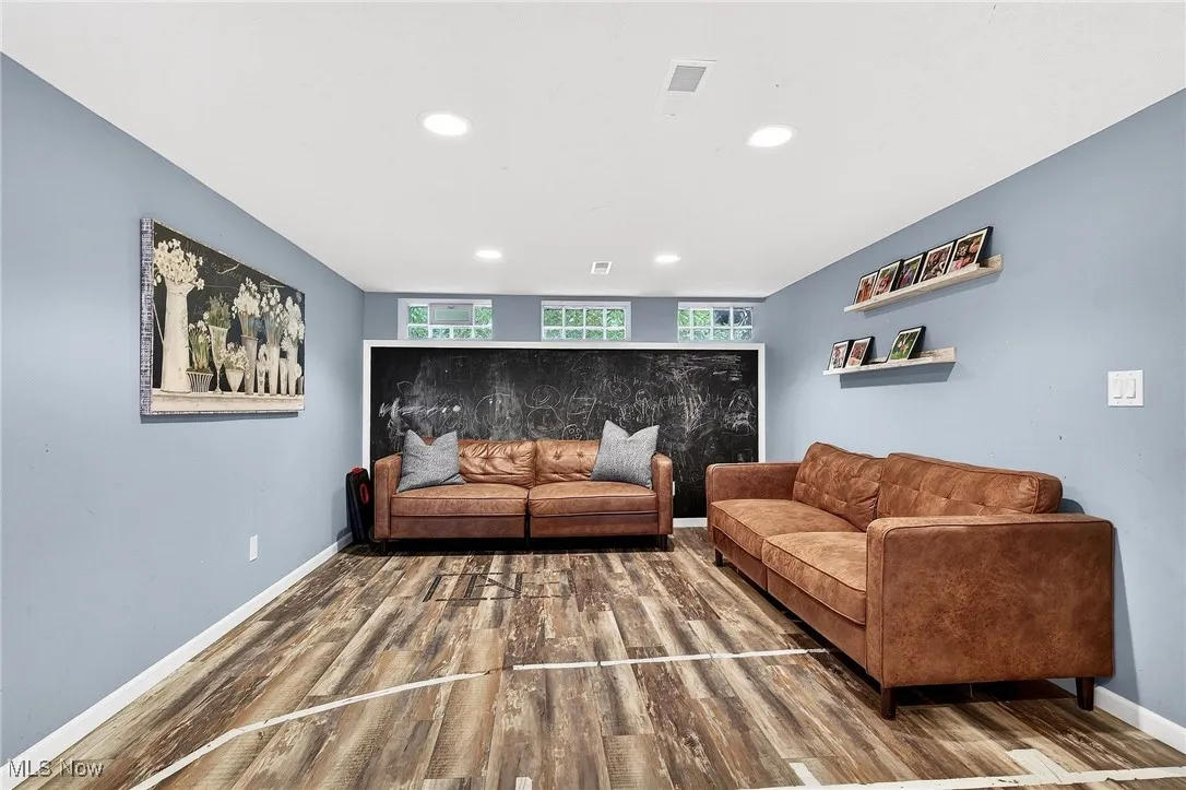 Living area with wood finished floors and recessed lighting