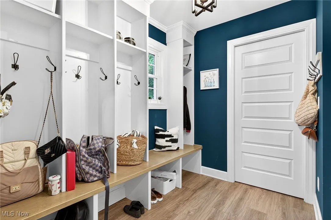Mudroom featuring light wood finished floors and baseboards