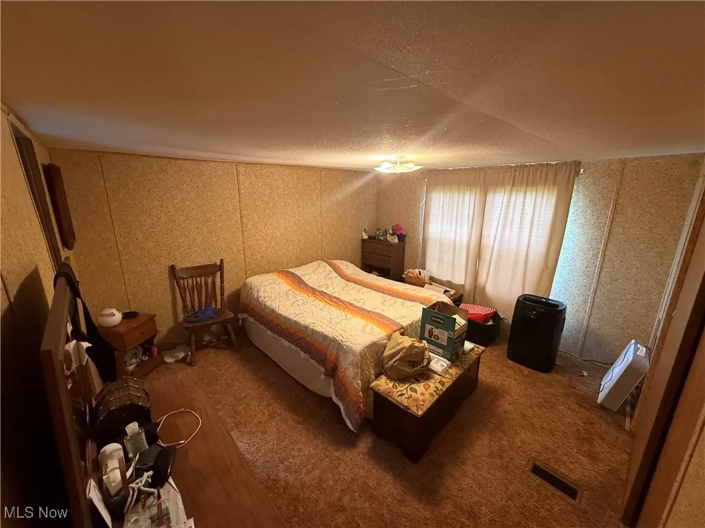 Bedroom featuring wood finished floors and a textured ceiling