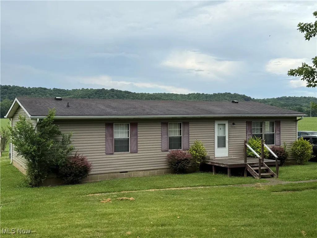 front view of house featuring a yard, crawl space, and a shingled roof