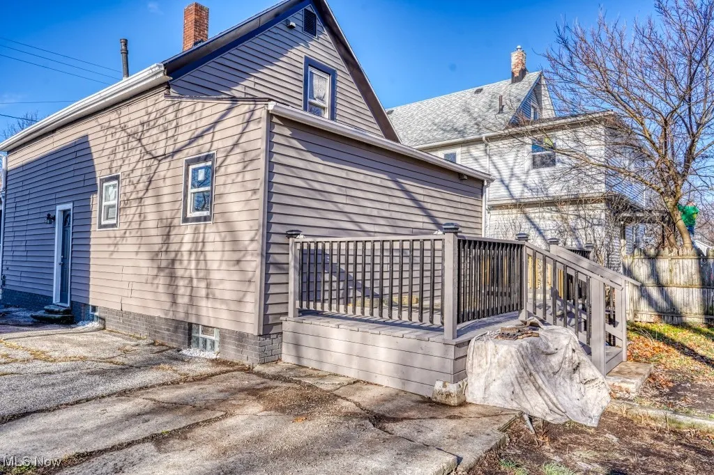 View of side of property featuring a chimney and a wooden deck