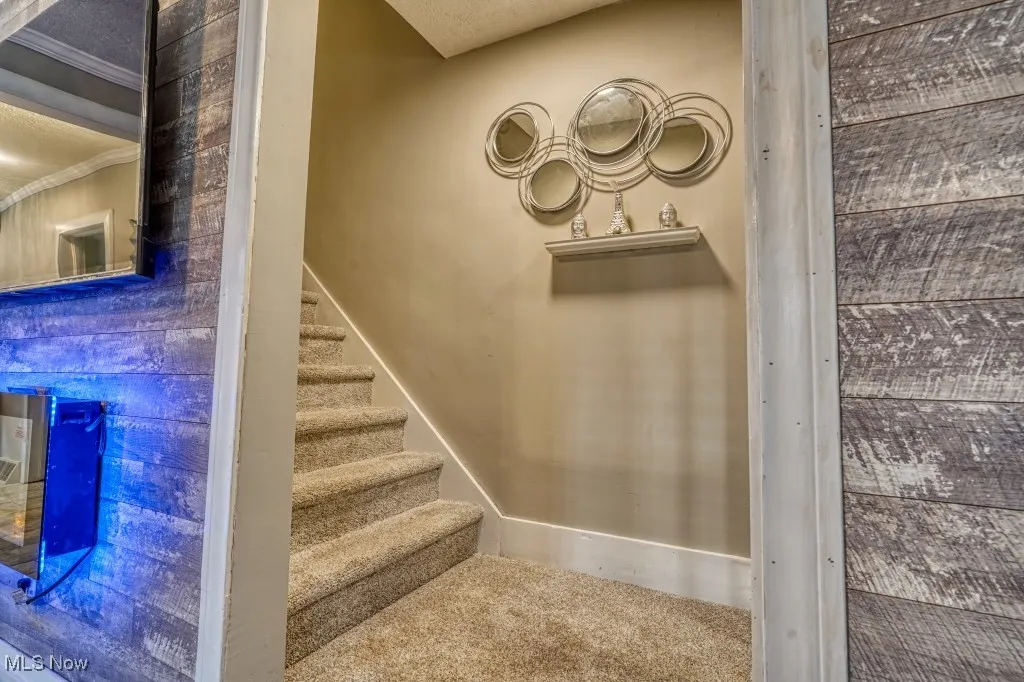 Stairs with crown molding and baseboards