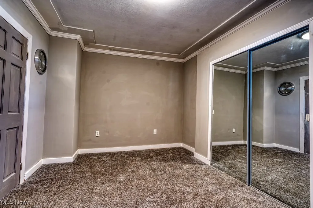 First Floor Master bedroom with carpet, a closet, and ornamental molding