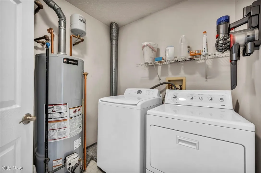 Laundry room with water heater and washer and dryer