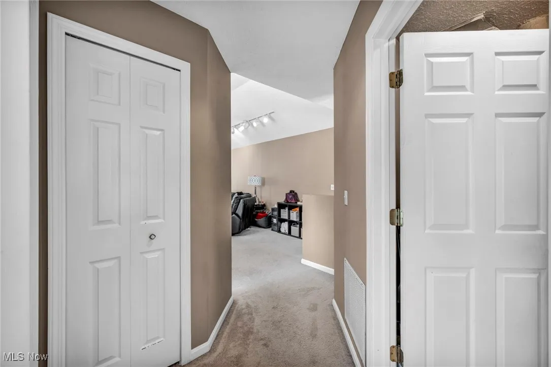 Hall featuring carpet and baseboards
