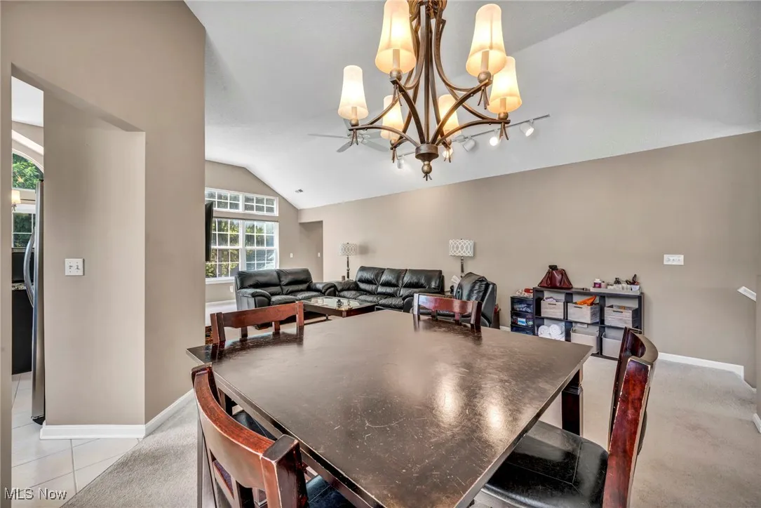 Dining space featuring a chandelier, lofted ceiling, and light tile patterned floors