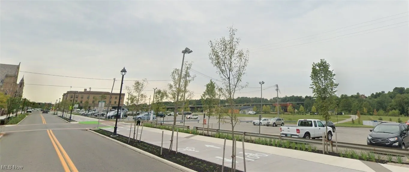 View of asphalt road featuring street lights and curbs