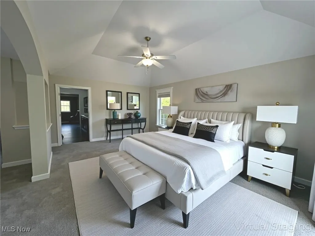 Bedroom featuring NEW carpet, ceiling fan, lofted ceiling, and arched walkways - virtually staged