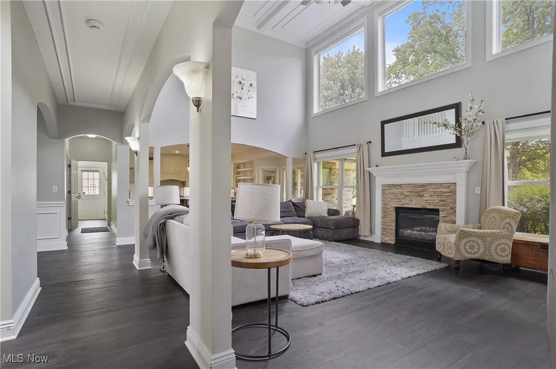 two story great room with arched walkways, new lvt flooring and a stone fireplace