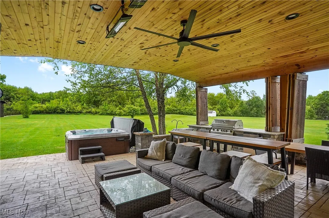 View of patio with outdoor lounge area, ceiling fan, and view of private yard