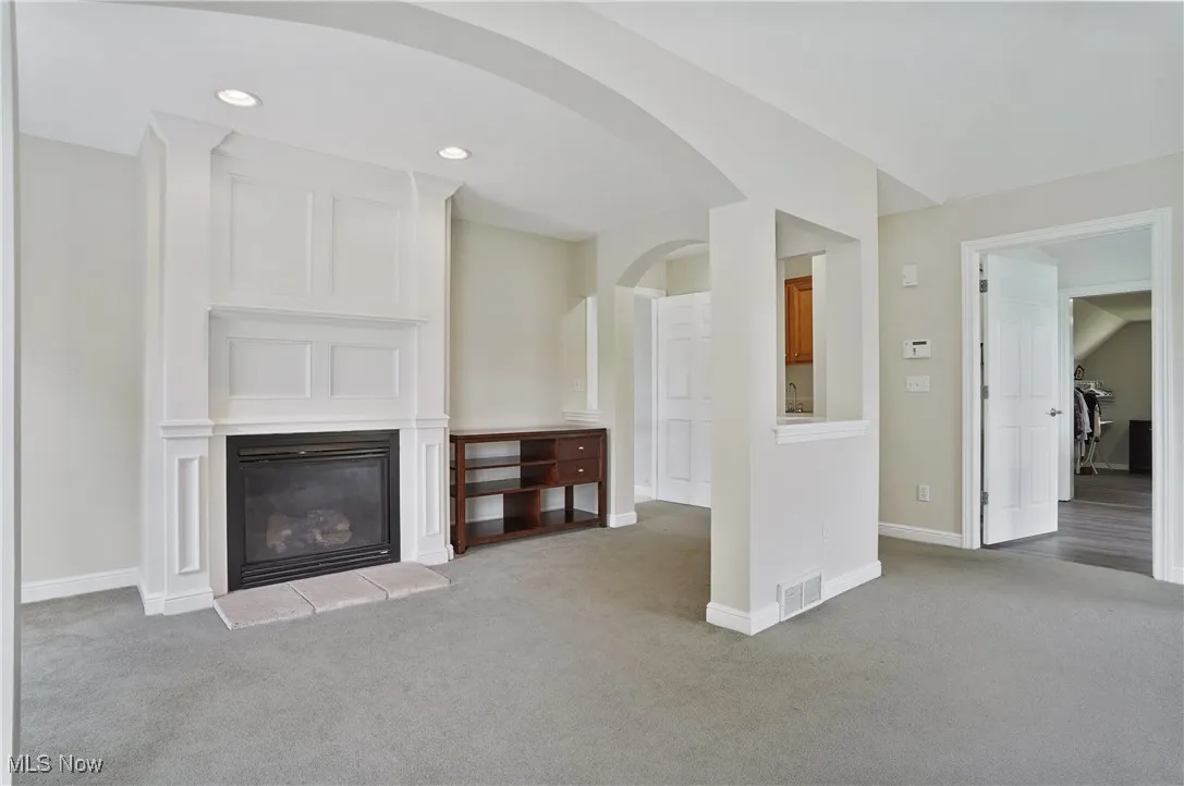 primary bedroom with sitting area, fireplace, arched walkways, wet bar and ensuite glamour bath