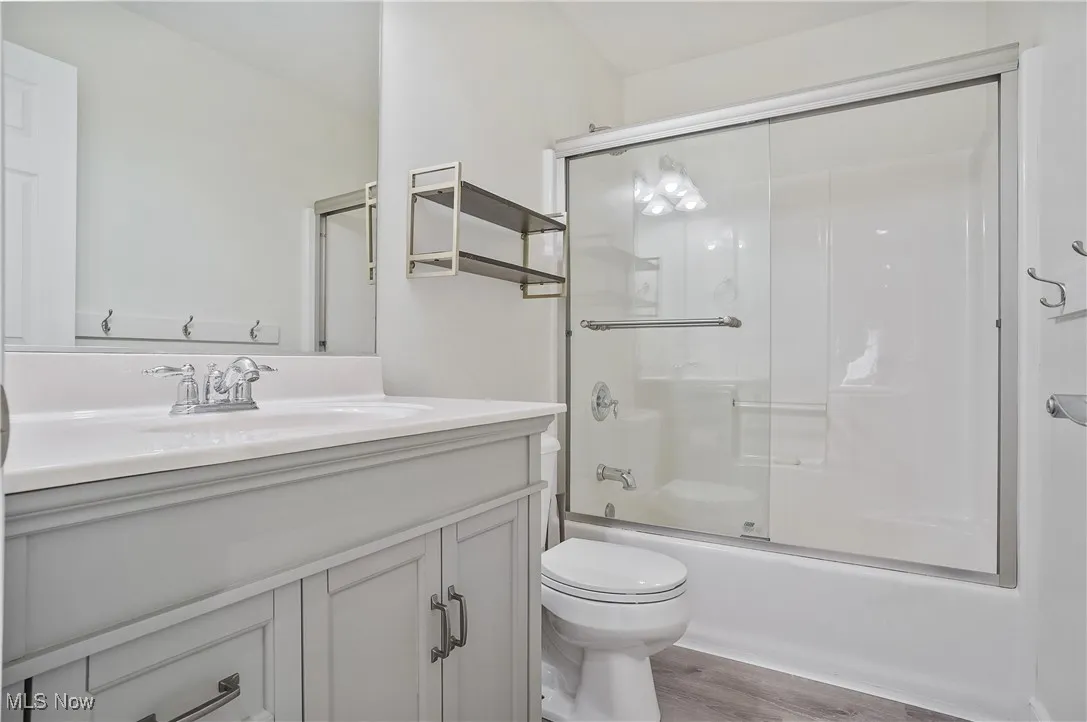 second floor hallway Bathroom with vanity, bath / shower combo with glass door, and lvt floors