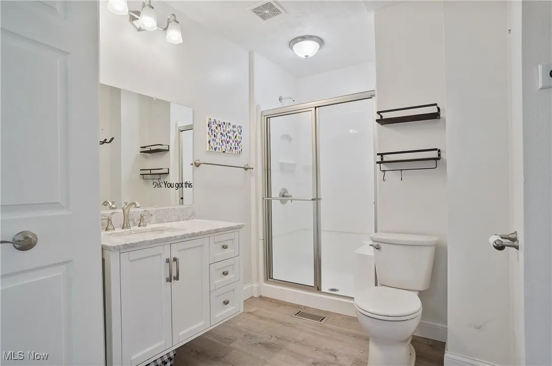 Full bath attached to upstairs bedroom featuring vanity lvt floors, and shelving