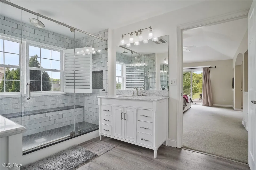 Ensuite primary bathroom his/her sinks, large tile shower with plantation shutters