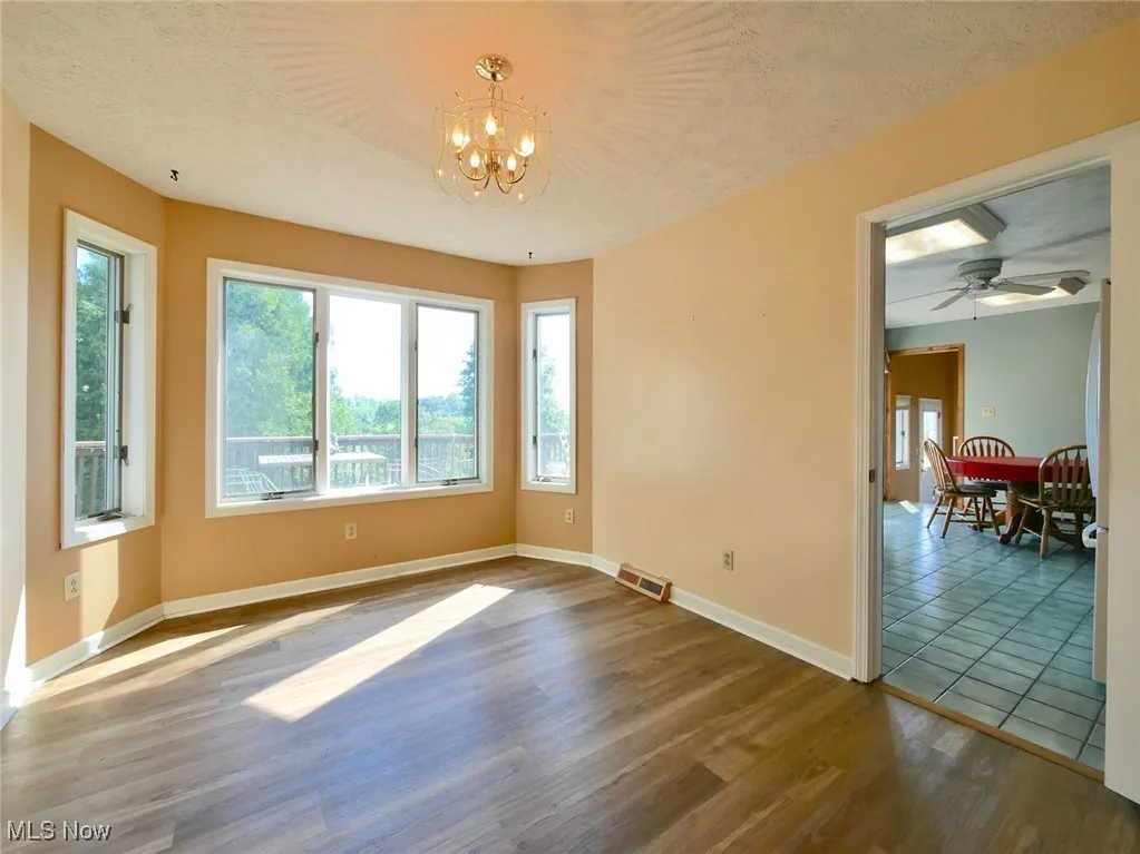 Spare room with a chandelier and wood finished floors