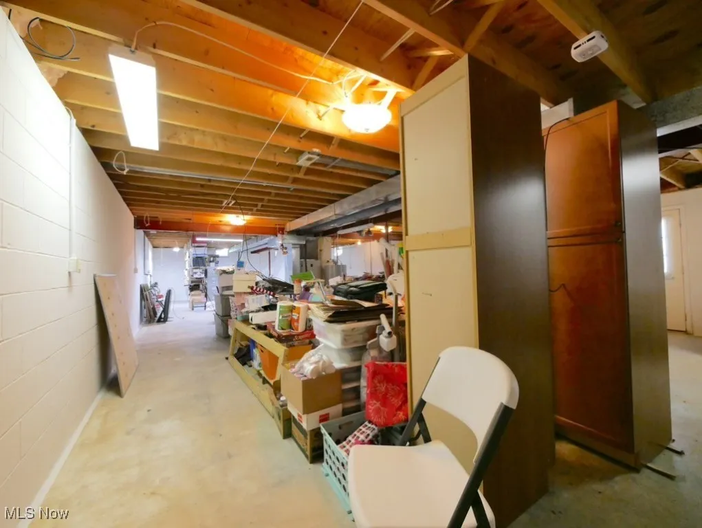 Unfinished below grade area with concrete block wall and a workshop area