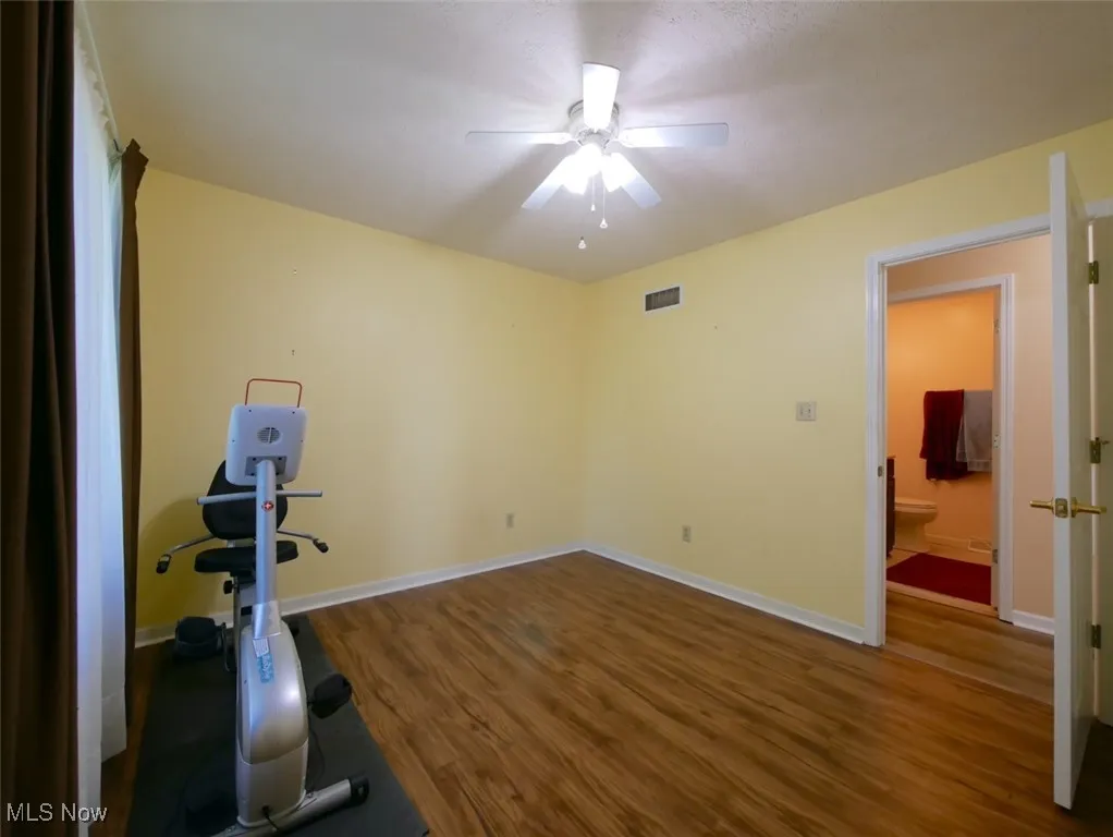 Workout room with wood finished floors and a ceiling fan