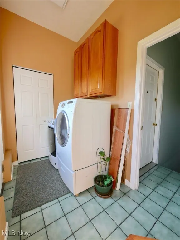 Washroom featuring washer / clothes dryer and light tile patterned floors
