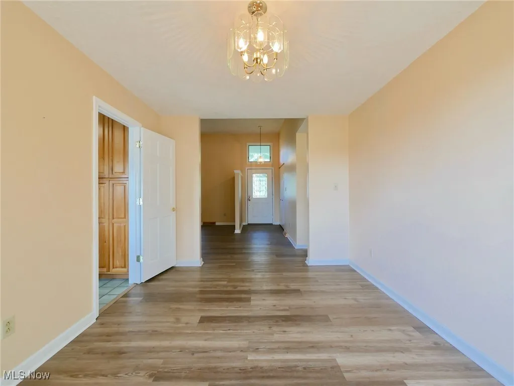 Hallway featuring a chandelier and light wood finished floors