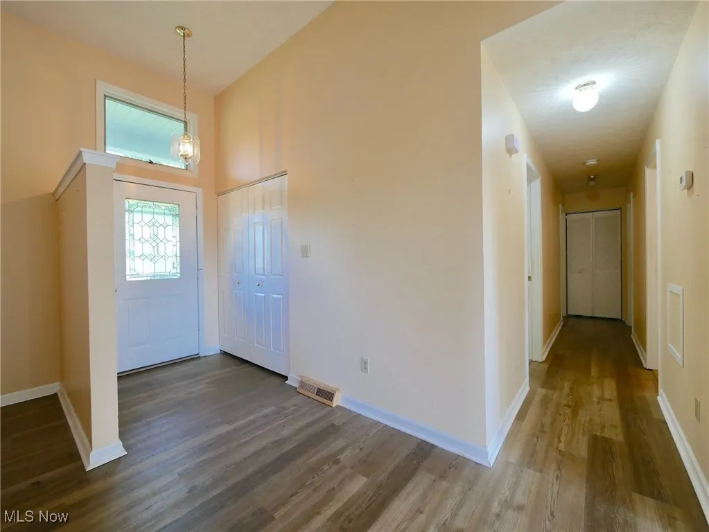 Entryway featuring wood finished floors and a towering ceiling