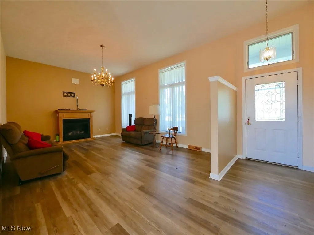 Entrance foyer featuring a chandelier, wood finished floors, and a fireplace