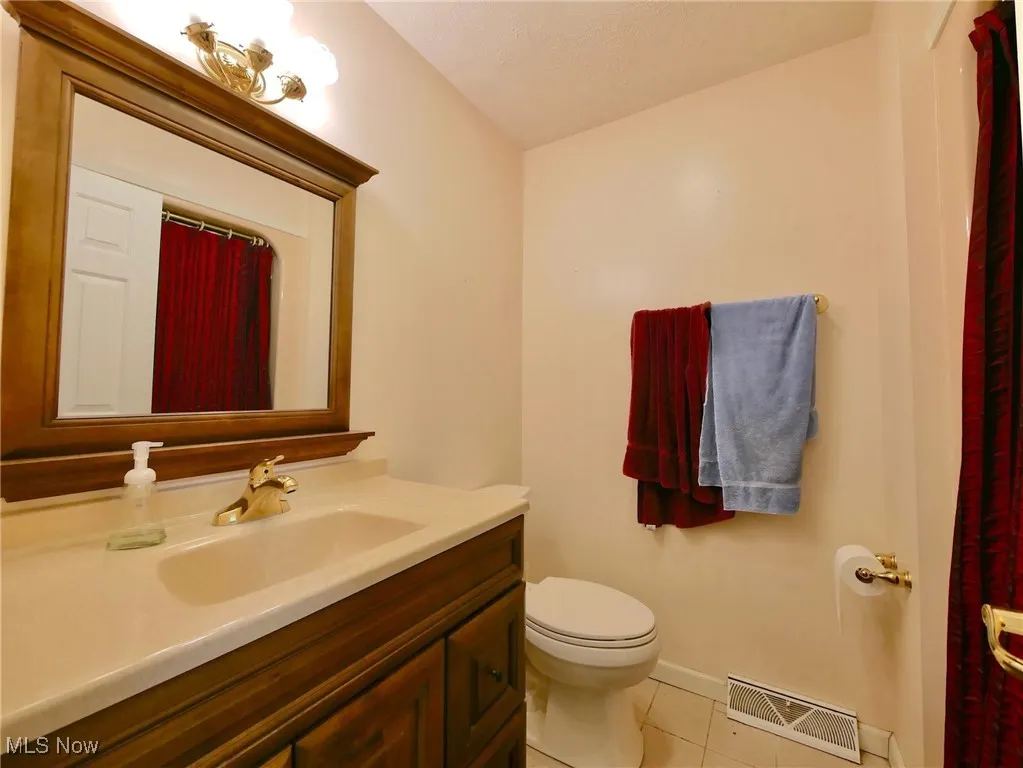 Full bathroom featuring vanity, tile patterned floors, and a shower with curtain